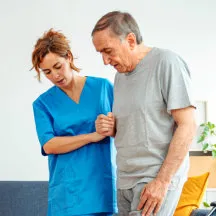 caregiver helping senior to walk