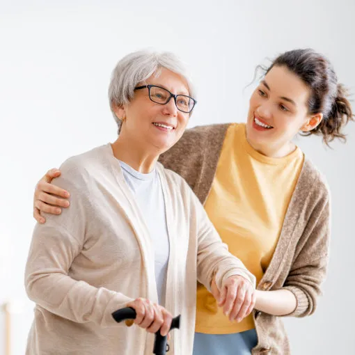 woman helping senior to walk