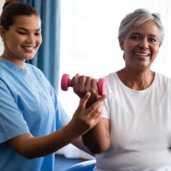 caregiver helping senior to exercise