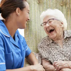 senior and caregiver laughing