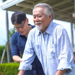 man helping senior to walk